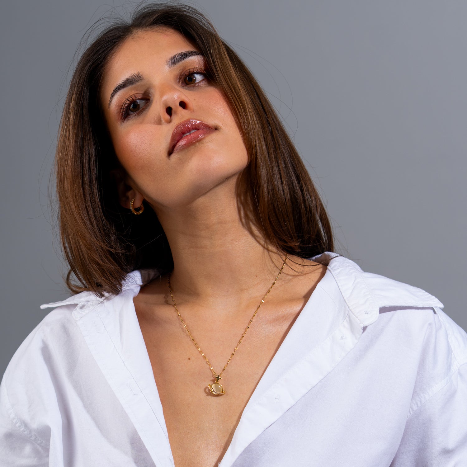 Starlight Planet gold pendant necklace with round beige Cat’s Eye gemstone, tiny star charm, and CZ accents on a fine gold chain.