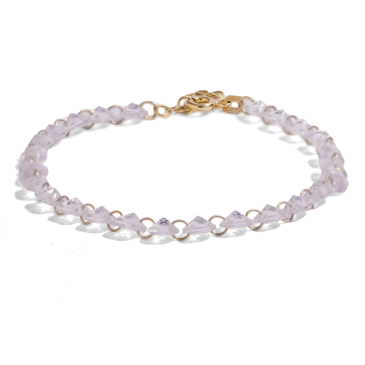 Starlight Trillion Cut Zircon Gold Tennis Bracelet, a line of trillion cut white zircons joined by small gold rings