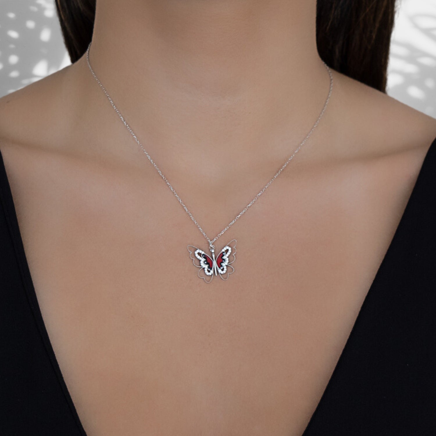 A model wearing the Sterling Silver Peace Red Butterfly Necklace, showcasing its elegance and symbolism.