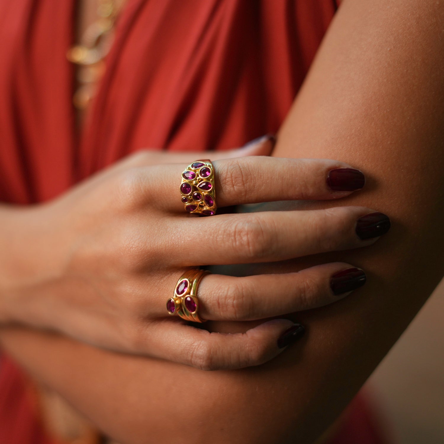 Luxurious adjustable ring with teardrop ruby stones and a gold-plated brass base, offering a blend of timeless elegance and practical design.
