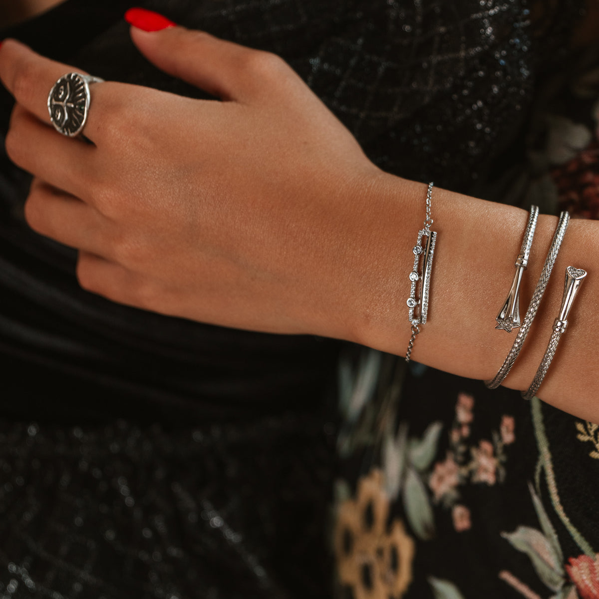 Three Lights silver bracelet on the wrist beside two silver bypass bangles, Guardian silver ring on the hand
