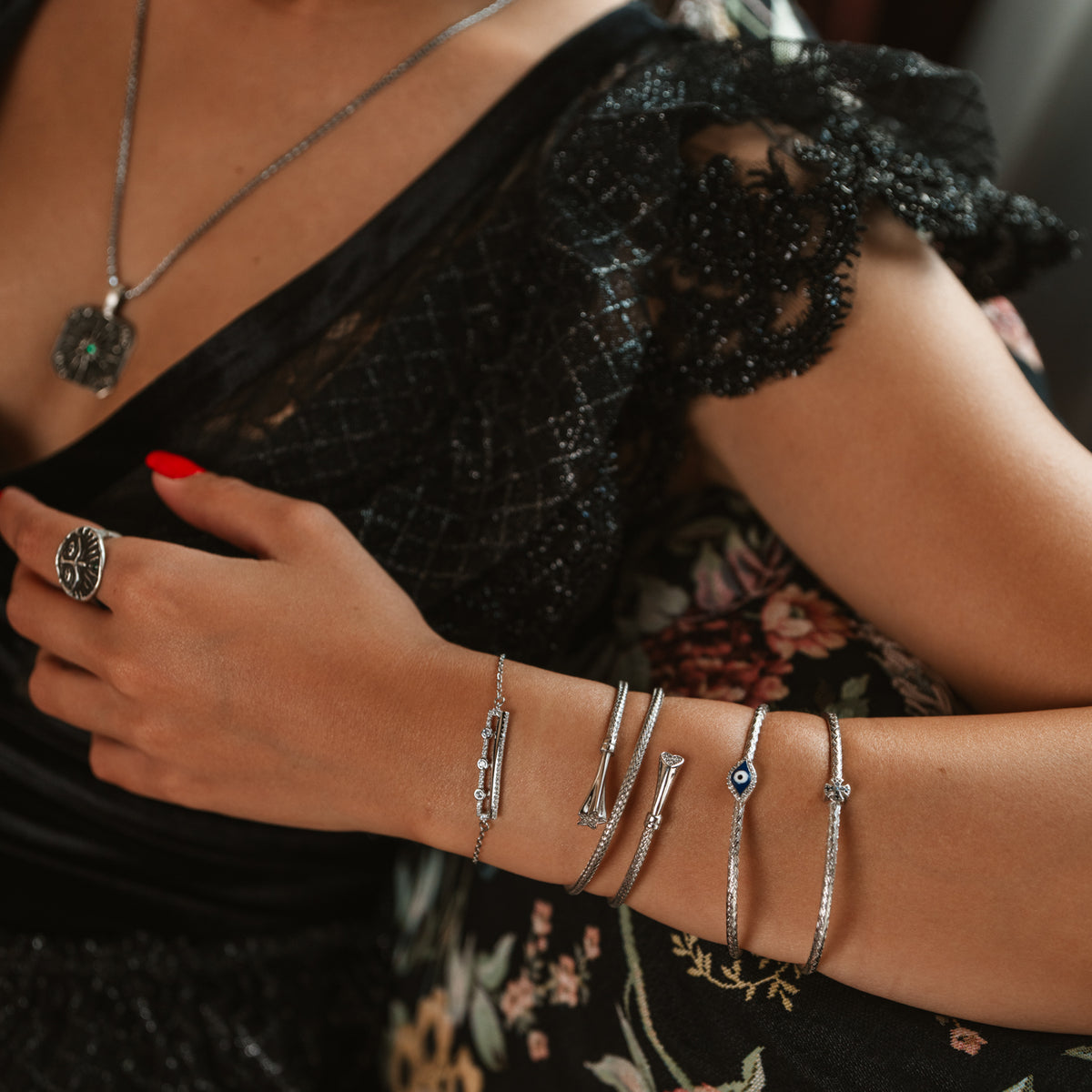 Model in black lace wearing the Three Lights silver bar bracelet with stacked silver bangles and the Guardian silver ring