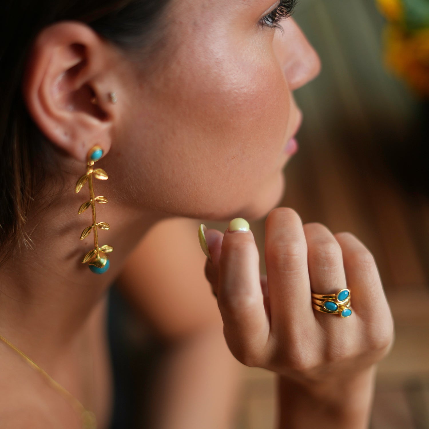 Adjustable turquoise gemstone ring with three striking stones set against a gold-plated base, combining elegance and versatility.
