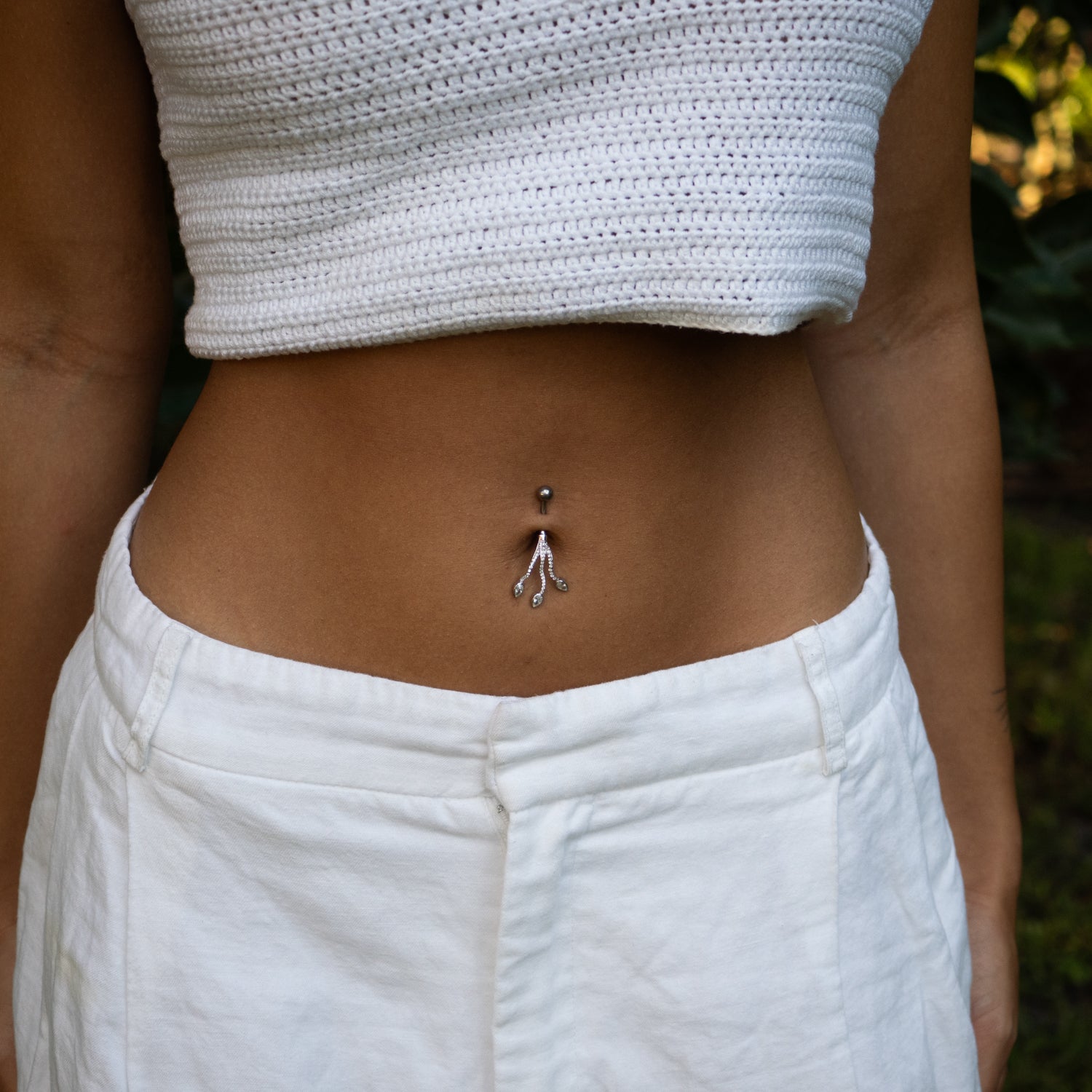Sterling silver belly piercing with three teardrop cubic zirconia stones on a branch design, sparkly, elegant, modern style.
