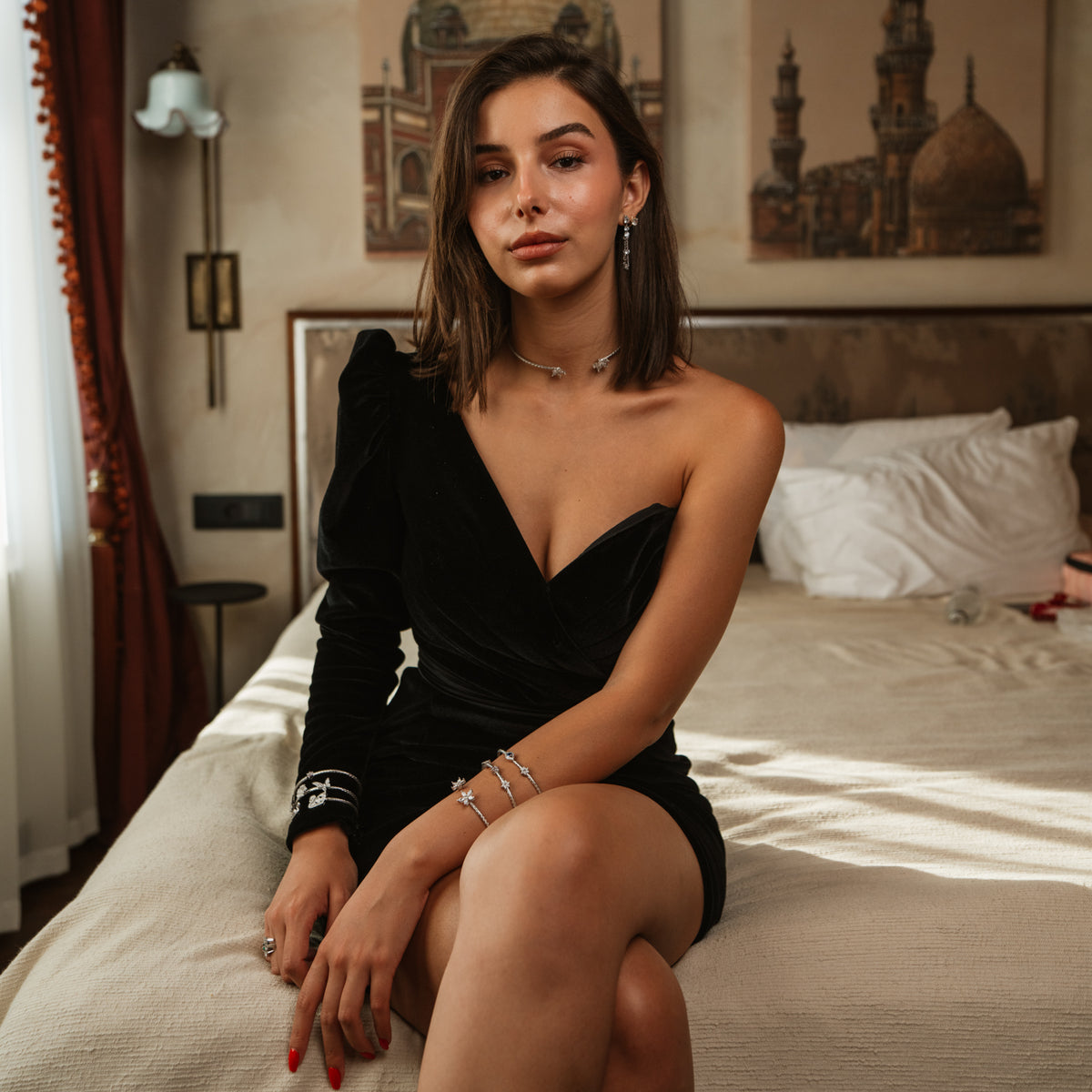 Woman seated in a velvet evening dress wearing a Twin Blossom woven silver collar necklace