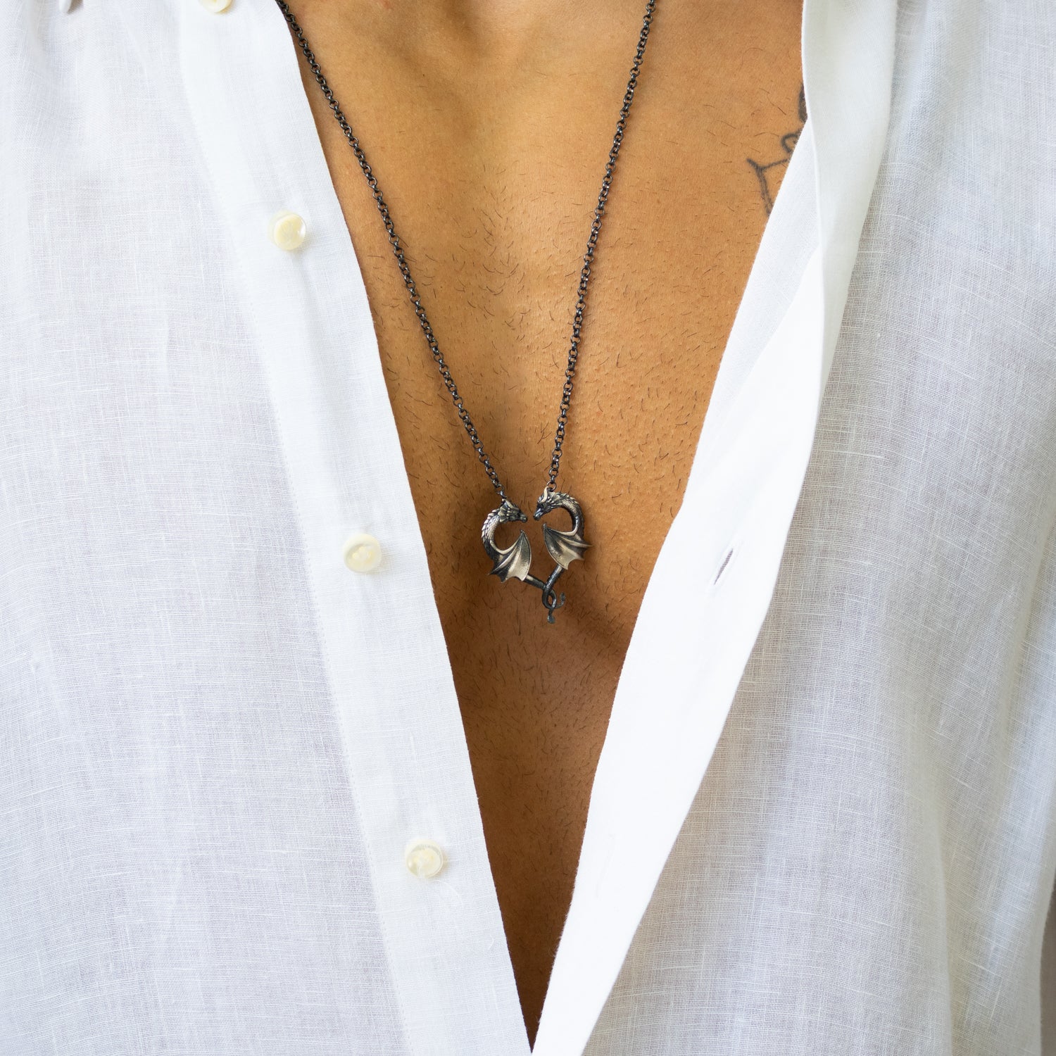 Sterling silver necklace featuring twin dragons forming a heart pendant, rhodium finish, detailed scales, black accents, bold masculine style.