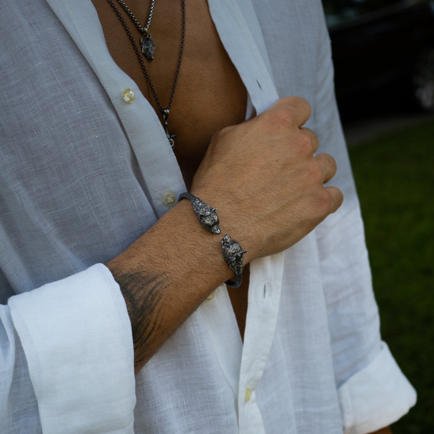 Bold sterling silver bracelet with two wolf heads, rhodium-plated, masculine style, handcrafted design, adjustable fit, unique detailing.