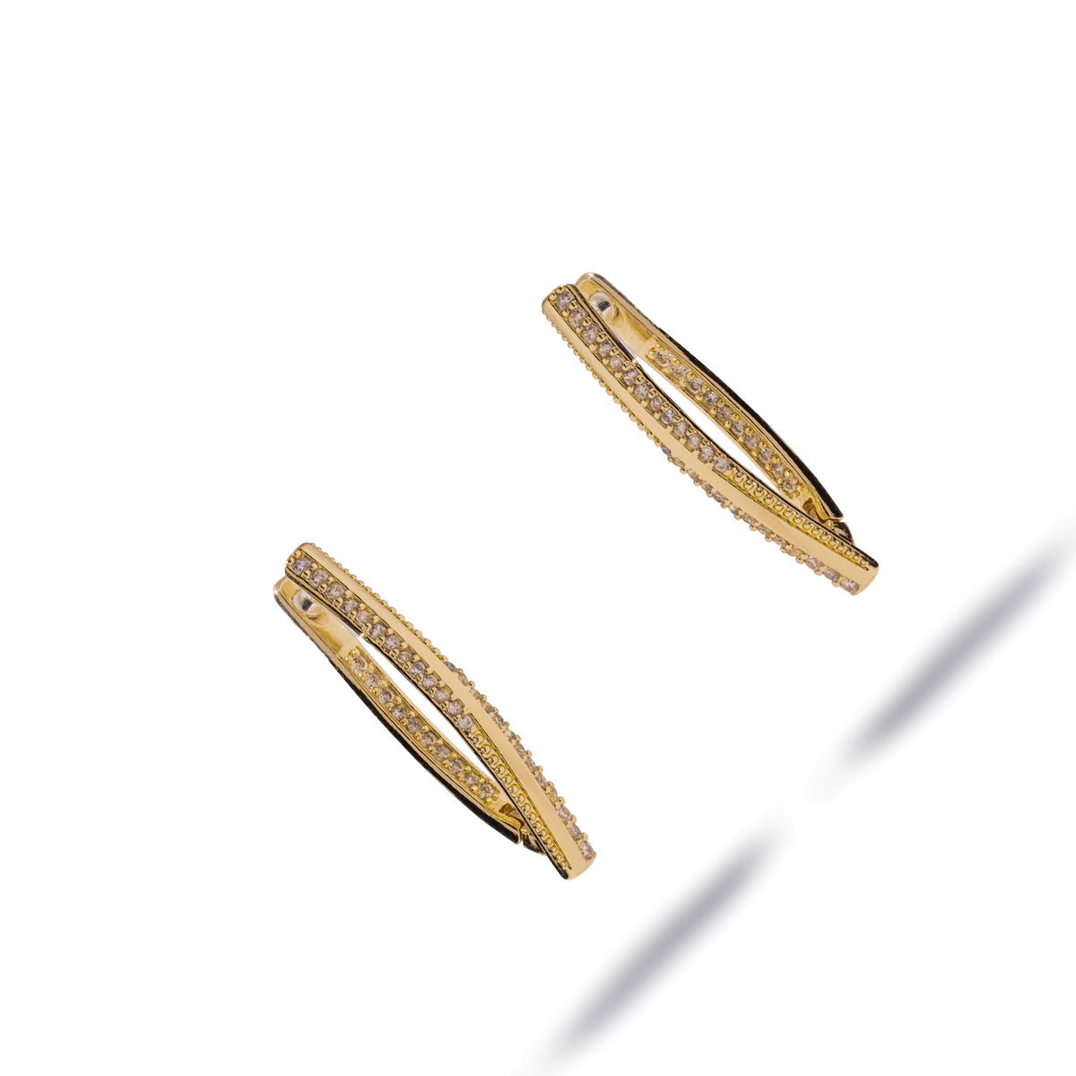 Twisted double row gold hoop earrings shown at an angle, revealing the hinged closure and inner row of stones