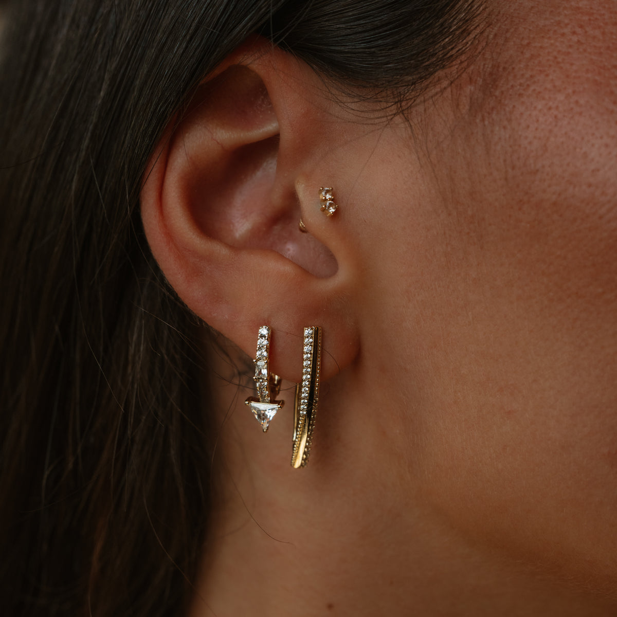 Ear stack with the twisted double row zircon gold hoop earring beside a pave drop huggie and a small stud