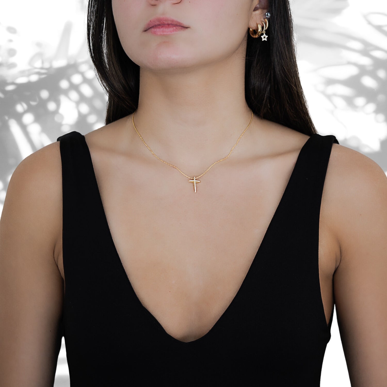 The Unique Cross Diamond Necklace beautifully complementing the model's outfit with its sparkle and unique design.