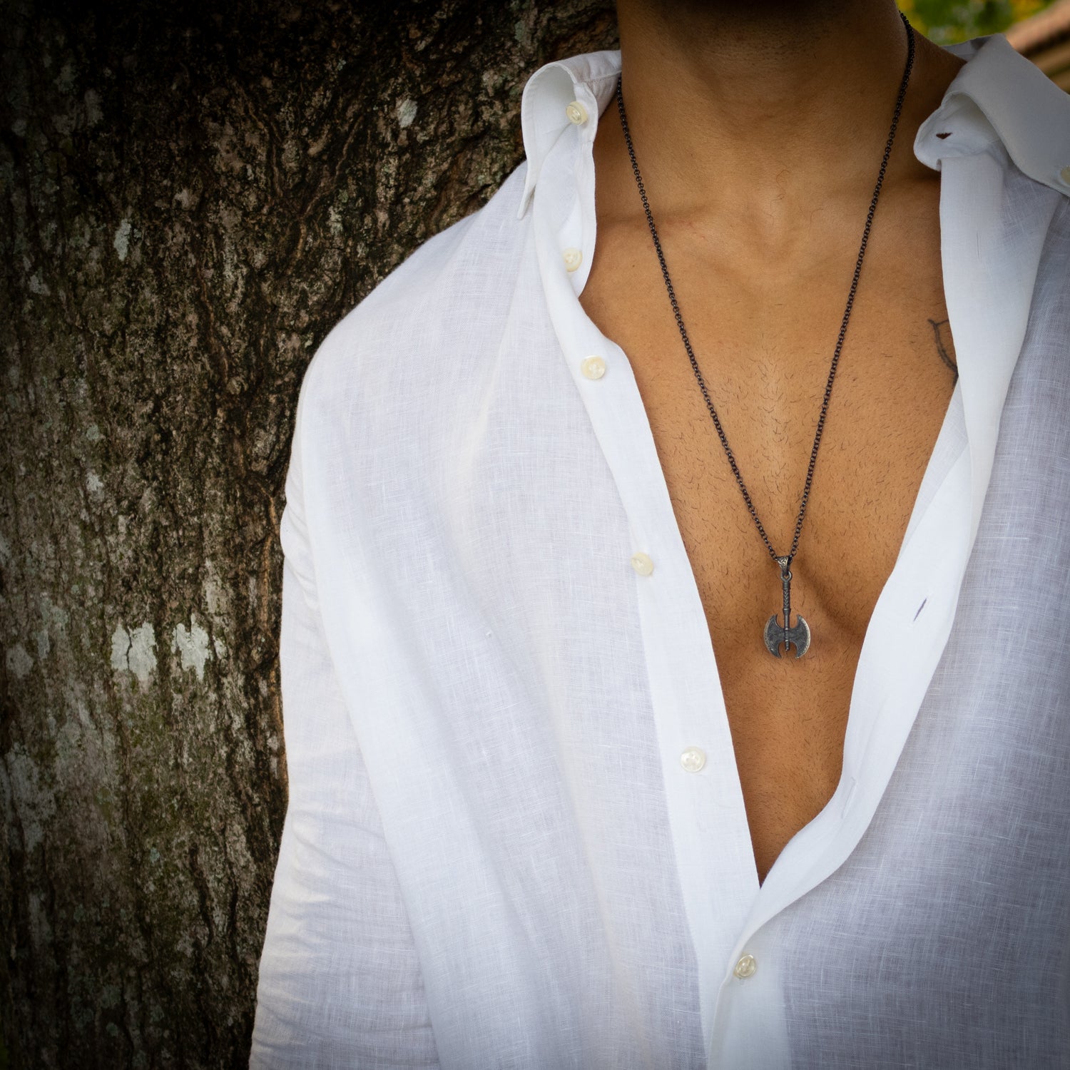 Sterling silver necklace with Viking axe pendant, rhodium finish, intricate engraved details, bold Norse warrior style symbolizing strength.