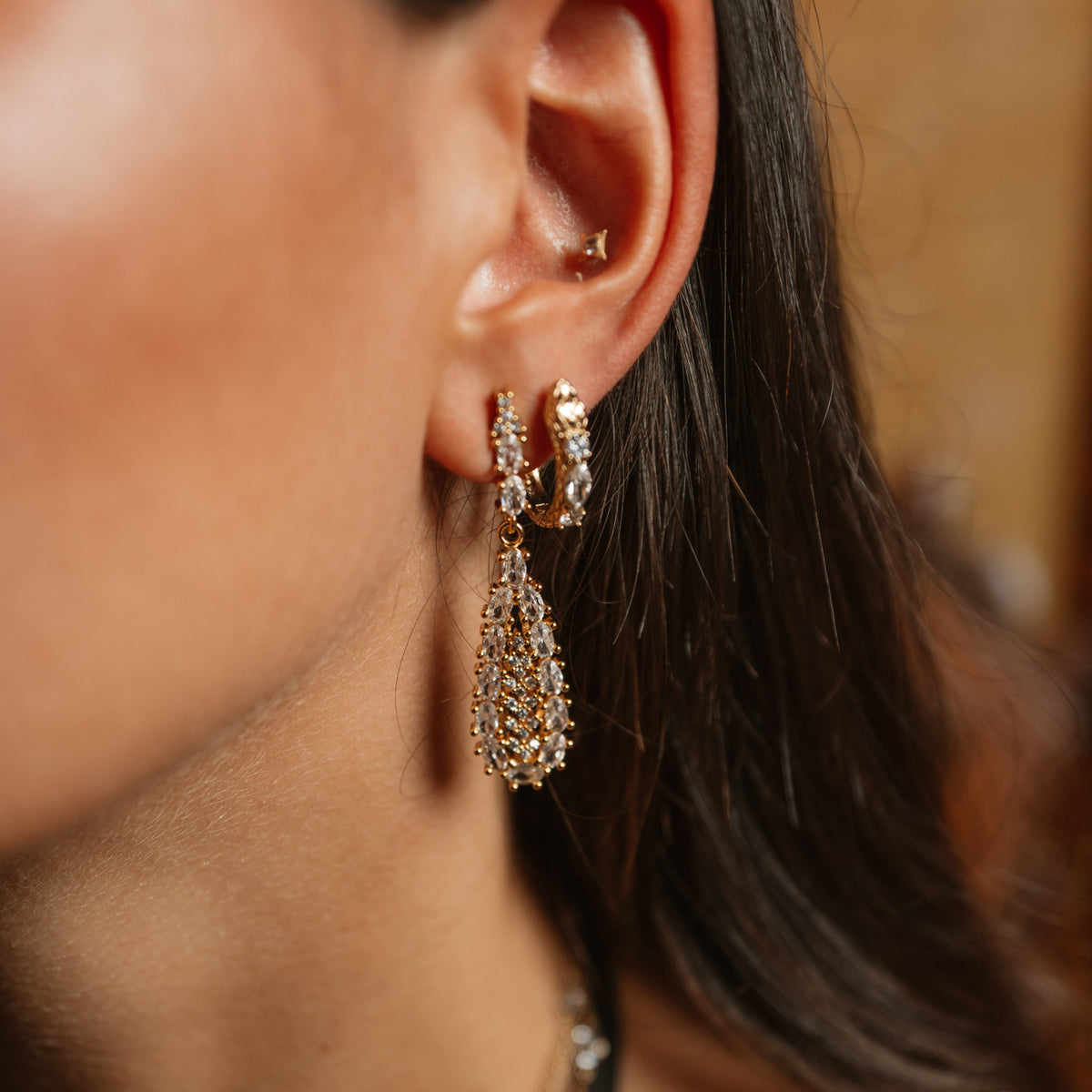 Close view of the vintage zircon teardrop gold earrings worn below the ear, showing the stone set top and the full teardrop drop