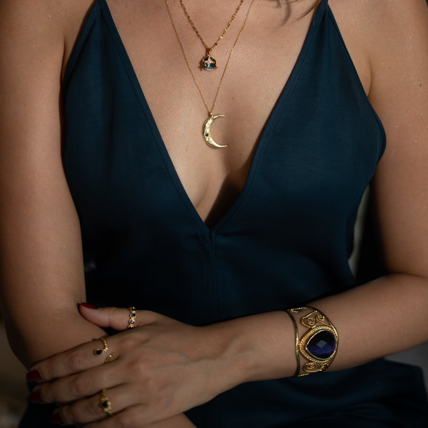 Vintage chunky cuff bracelet in 24k gold-plated bronze, featuring a navy blue cat eye stone and ornate gold swirl detailing