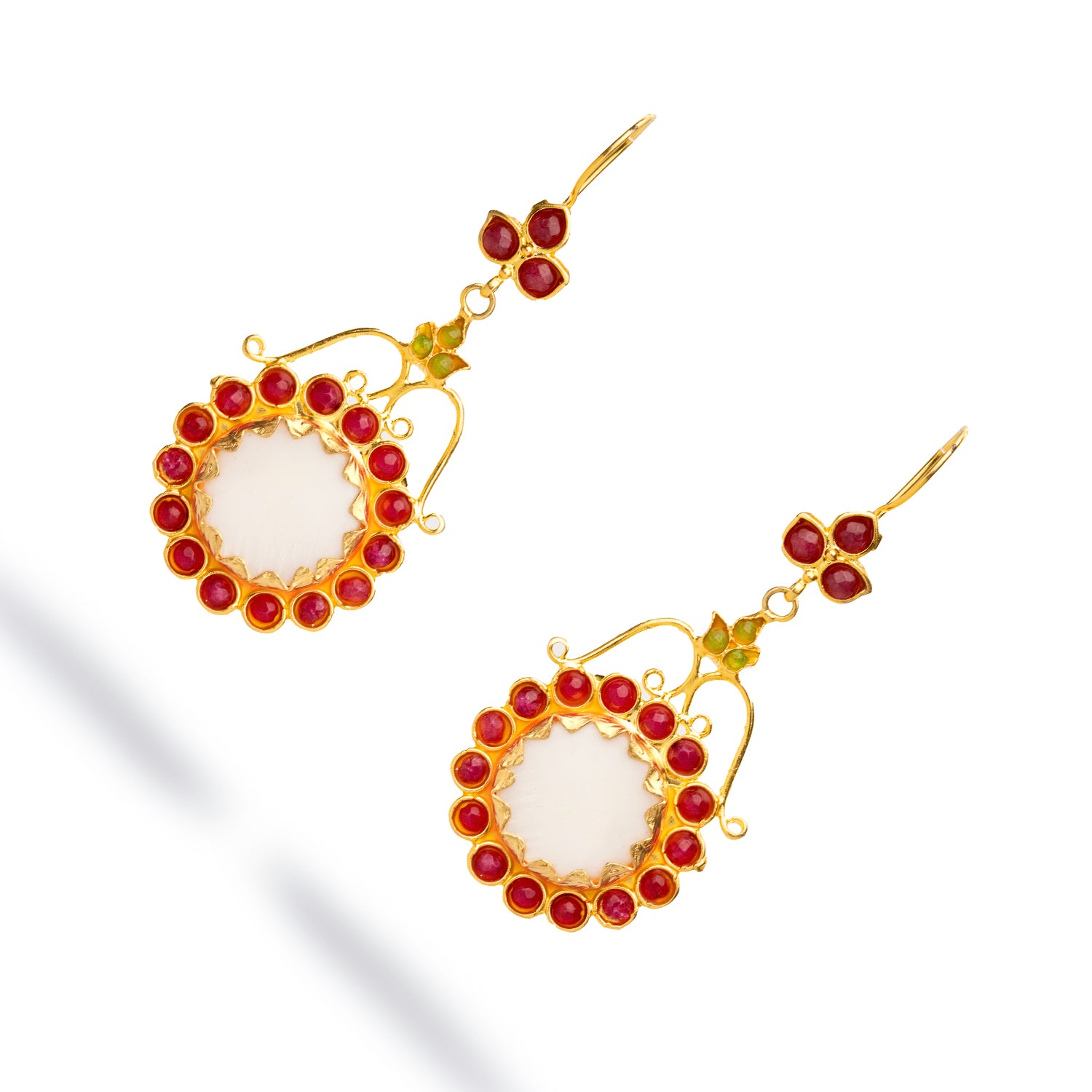 Bohemian-inspired chunky gold dangle earrings with a floral design, including a mother of pearl center and vibrant ruby and jade stones.
