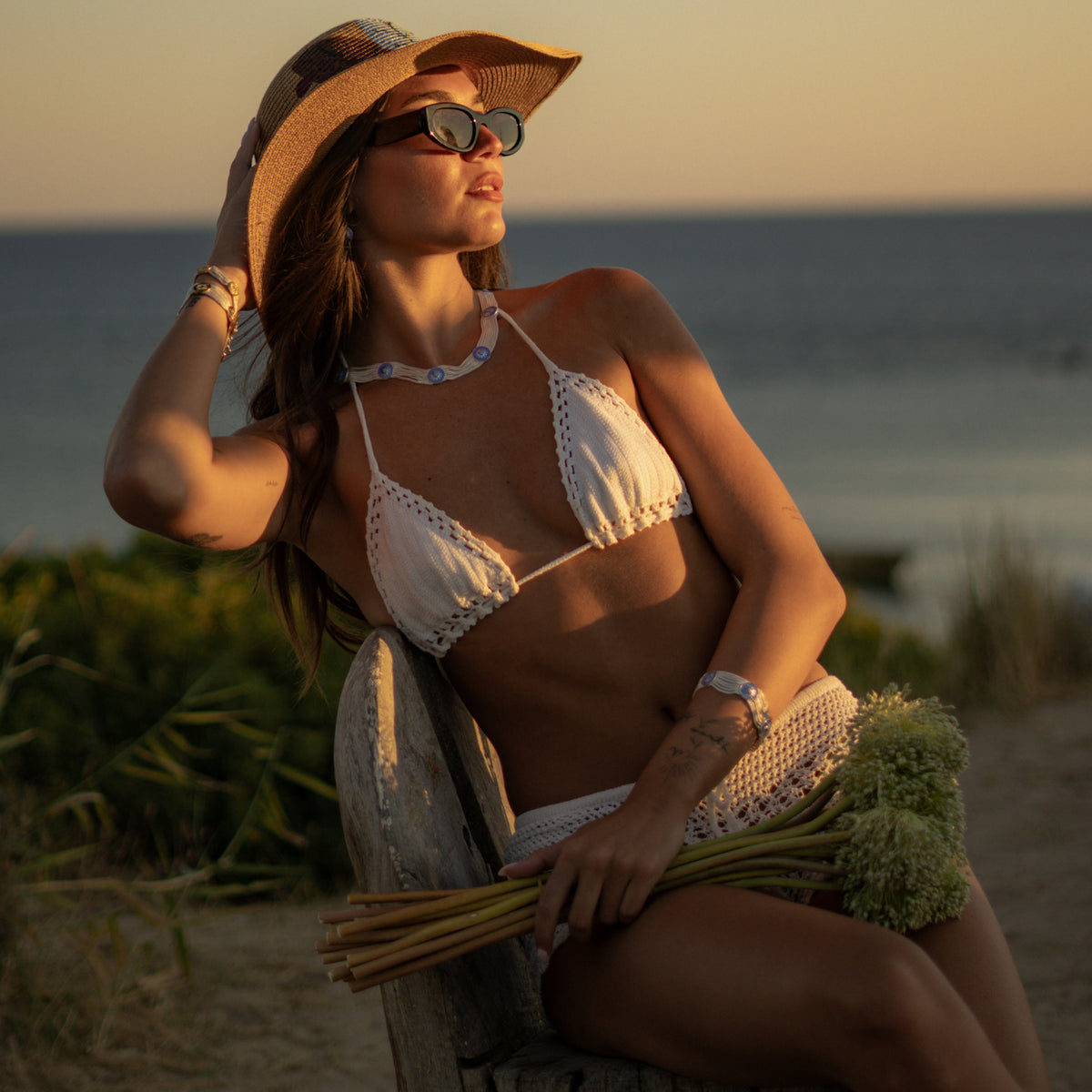 Model at the shore wearing the Cobalt Bloom enamel choker with the matching woven silver bracelet