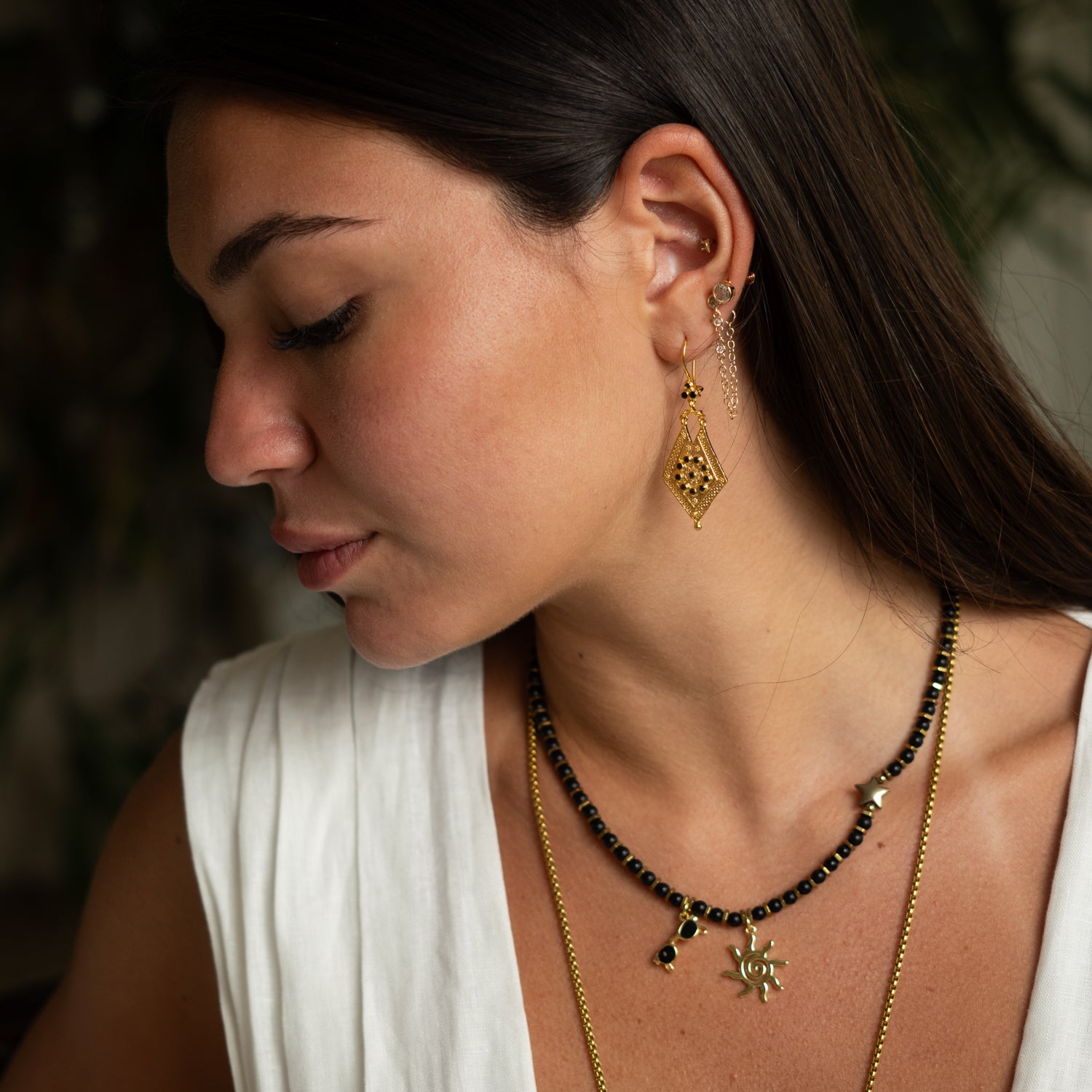 Side profile of model wearing Vintage Style Gold & Black Onyx Dangle Earrings by Ebru Jewelry.