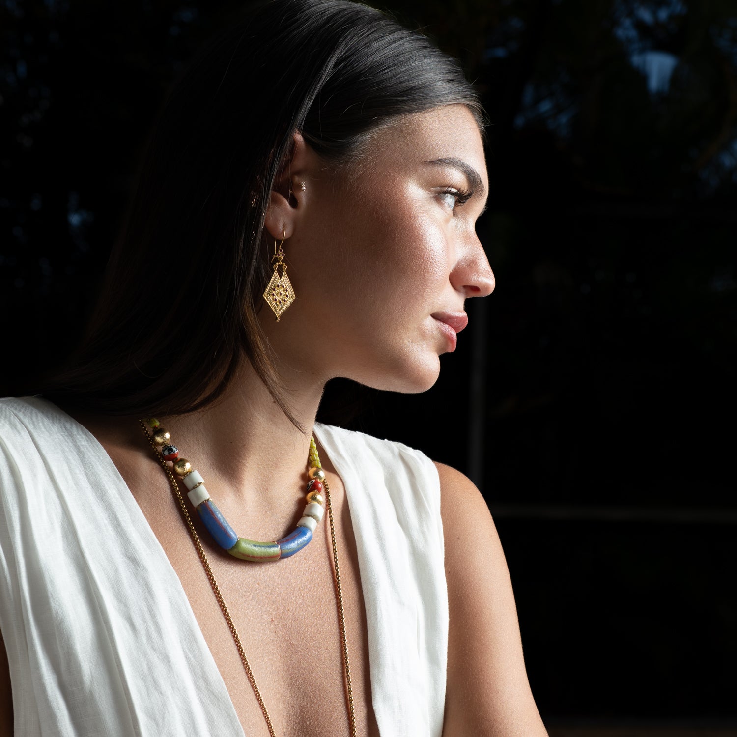 Brunette model styled with Vintage Style Gold & Ruby Dangle Earrings, layered with bold beaded jewelry for a bohemian summer look.