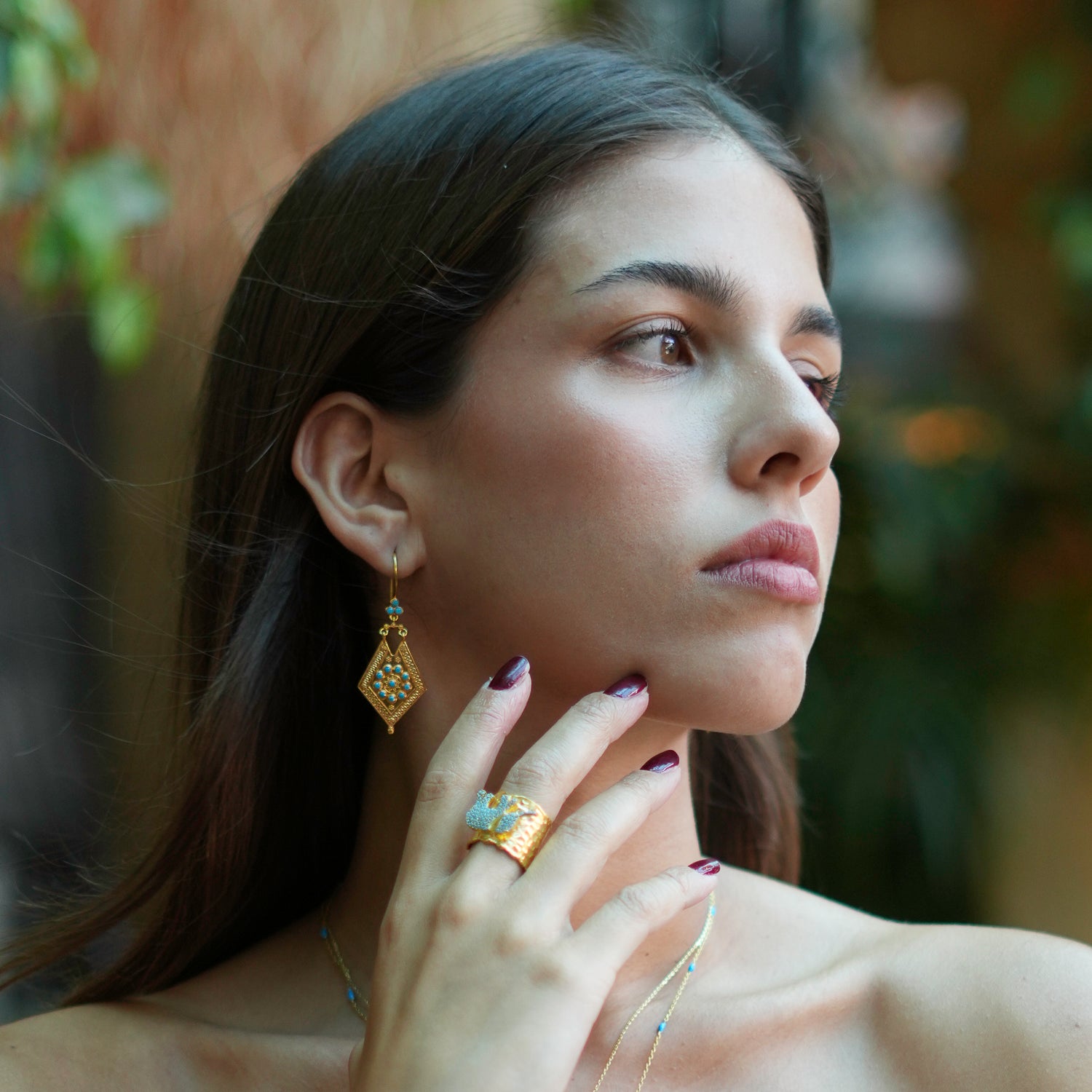 Beautiful dangle earrings with 24k gold plating and detailed gold accents, featuring vibrant turquoise stones for a refined vintage look.
