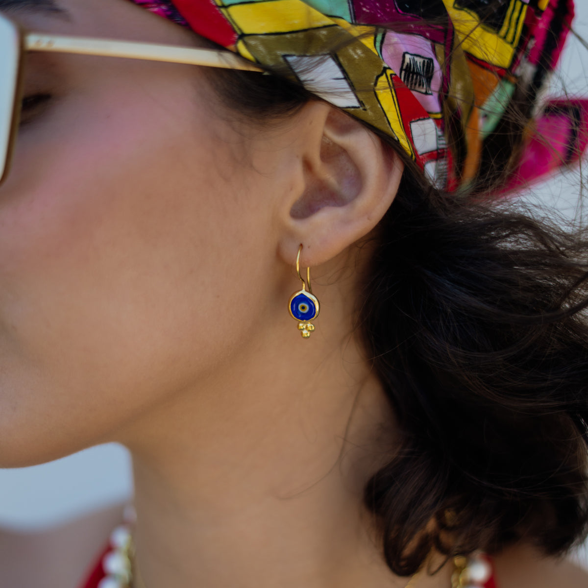 Side profile of the model wearing a Watch Over Me blue evil eye gold drop earring