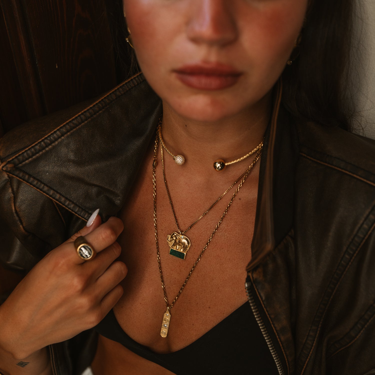 Woman styling woven gold vermeil pave sphere choker necklace layered with gold pendant necklaces