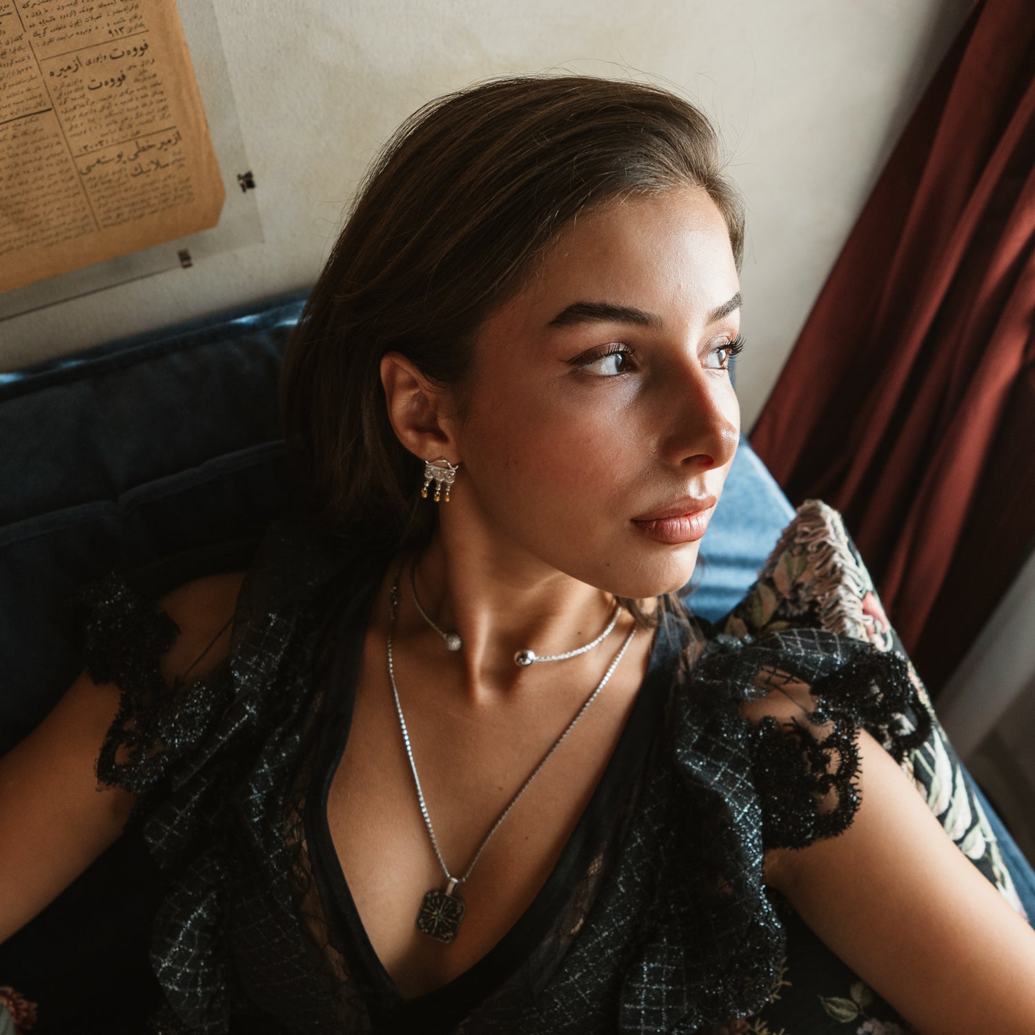 Woman wearing a sterling silver pave sphere choker layered with a long silver pendant necklace