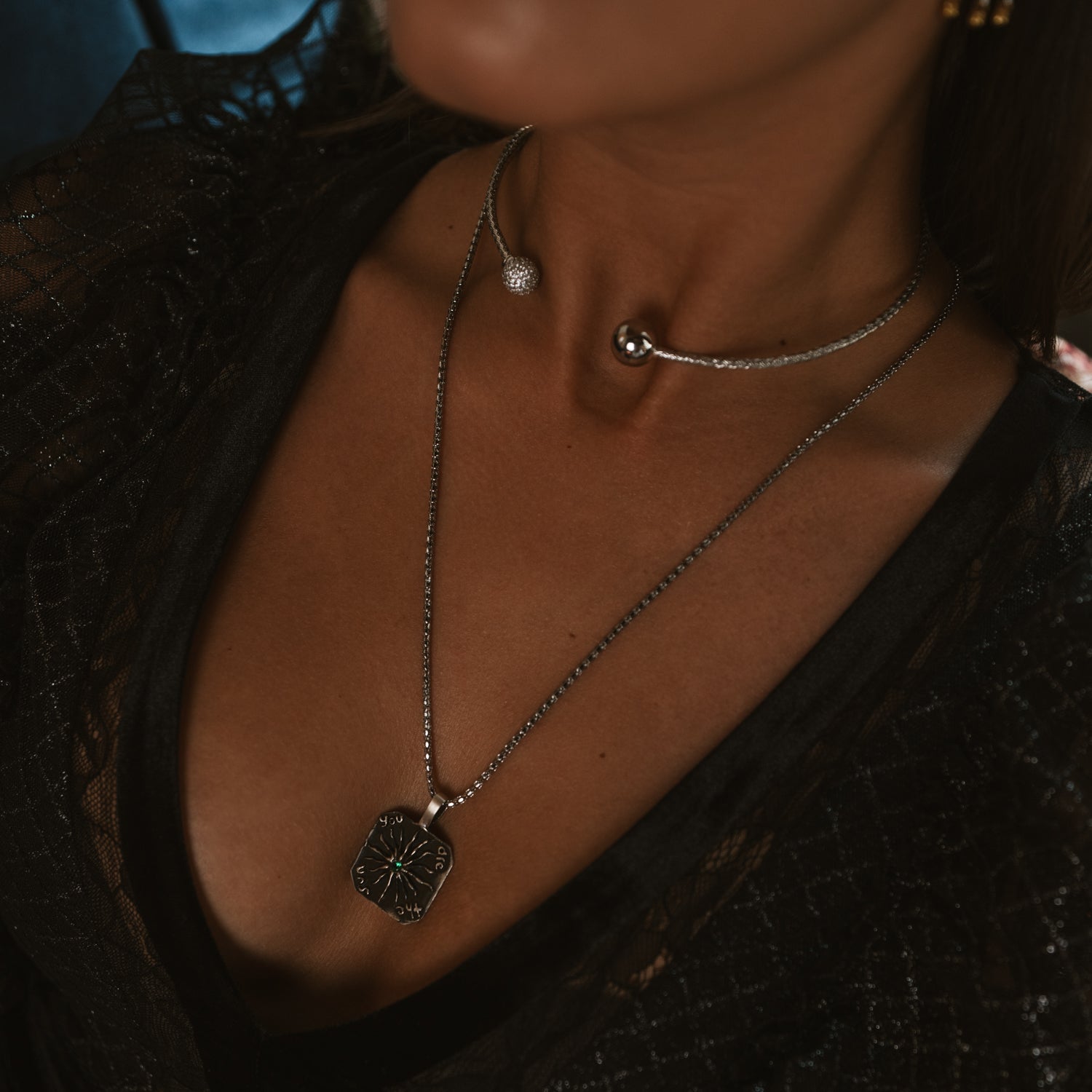 Close up of a sterling silver woven choker necklace layered with a silver pendant necklace