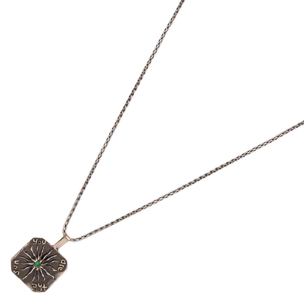 Angled view of the You Are The Sun silver pendant with hand worked lettering around the edge