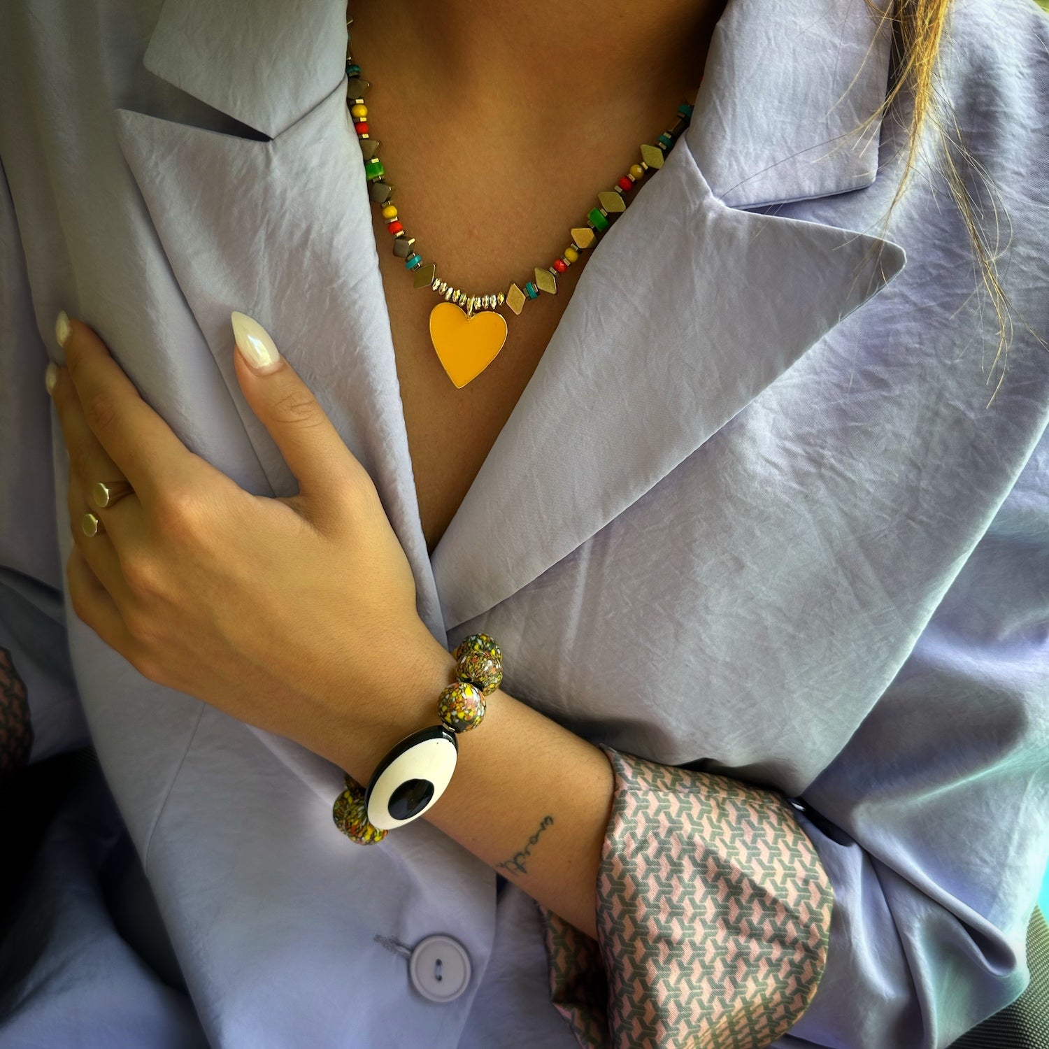 A model wearing the African Chunky Eye Bracelet; featuring a black and white Nepal Eye bead for protection, combined with chunky African and yellow jade beads