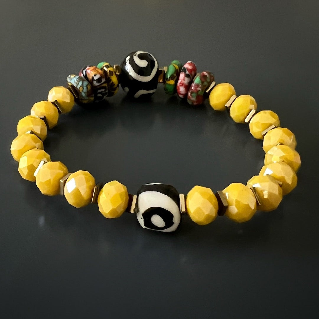 A close-up image of the African Yellow Women Bracelet, showcasing the unique spiral and eye Nepal beads mixed with colorful African and yellow crystal beads.