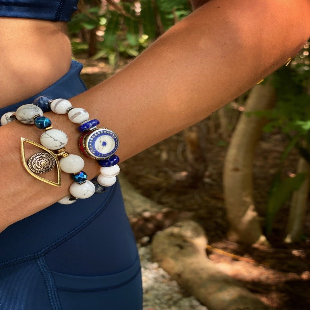 A Model Wearing Gold Evil Eye Charm Bracelet with Blue and White Stones