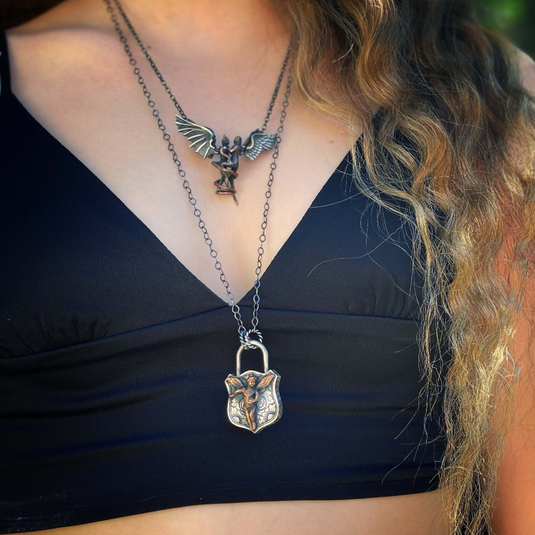 Stay protected and guided with the Angel Lock Necklace&#39;s angel charm, representing protection and guidance wearing by a model