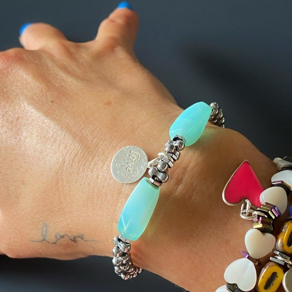 Hand Model Wearing Aquamarine Love Bracelet with Love Charm and Aquamarine Stones