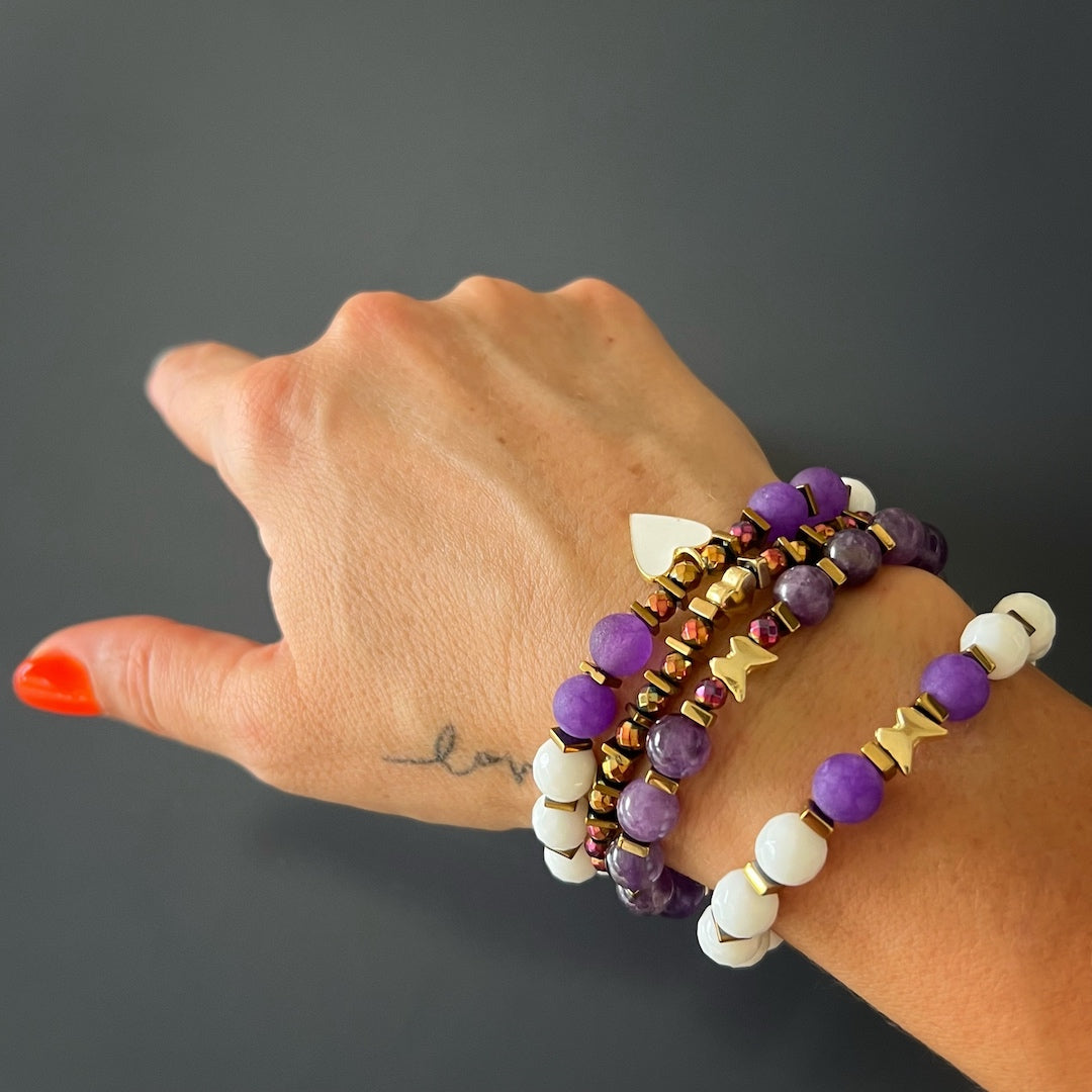 Hand model wearing the beautiful Amethyst stone bead bracelet with heart and butterfly charms.