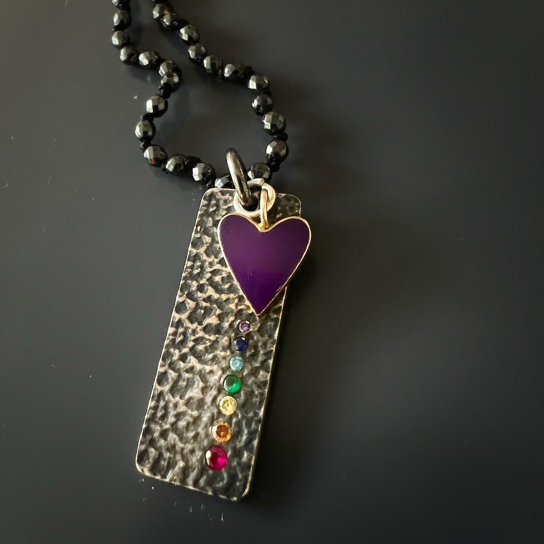 Chakra Balance Necklace featuring a stunning silver chakra pendant and a purple heart charm for spiritual well-being.