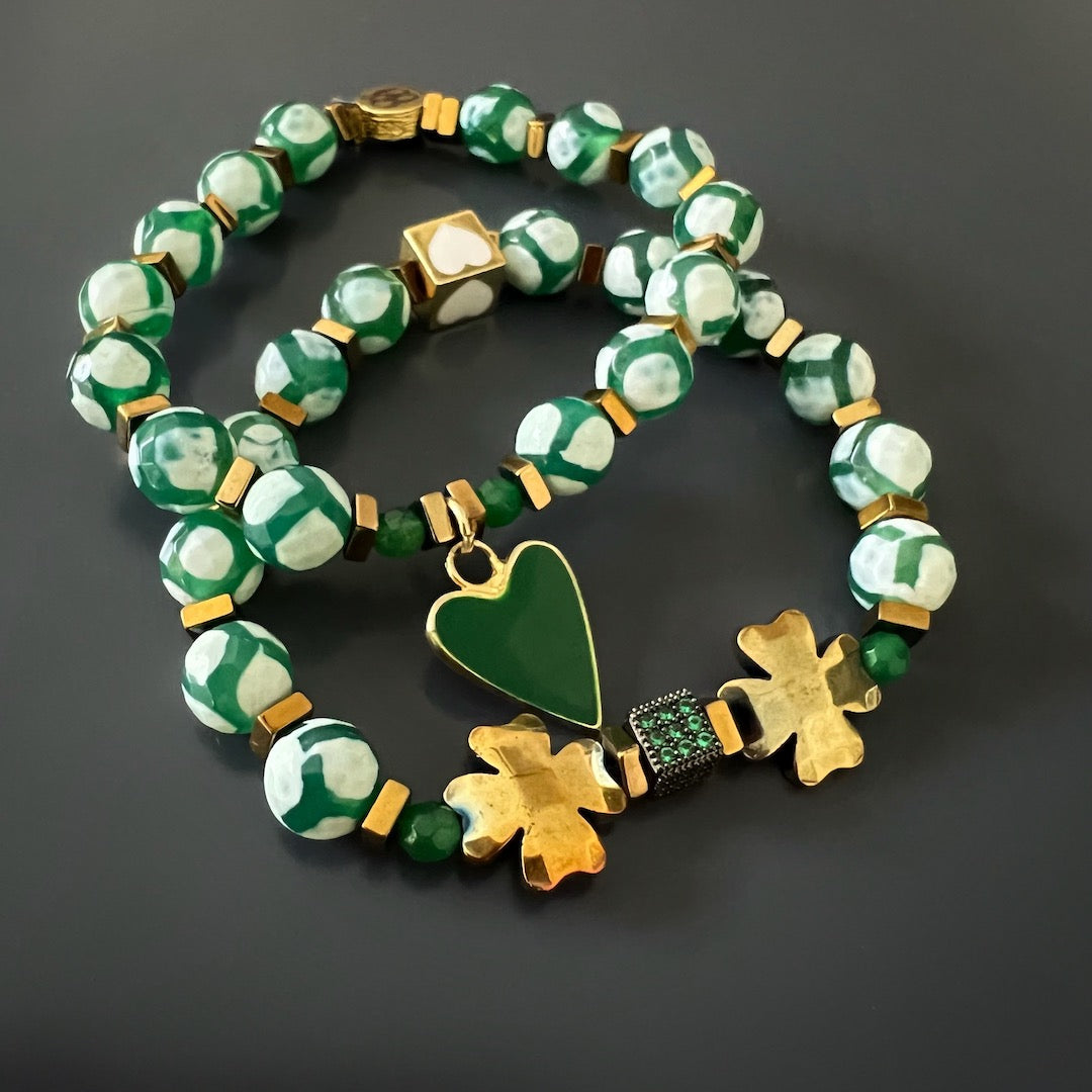 Handcrafted with love, this bracelet set showcases the beauty of Nepal Agate beads and gold hematite clover leaf beads. The 18K gold-plated green enamel heart charm and white enamel heart bead bring a touch of whimsy and romance to this timeless piece of jewelry.