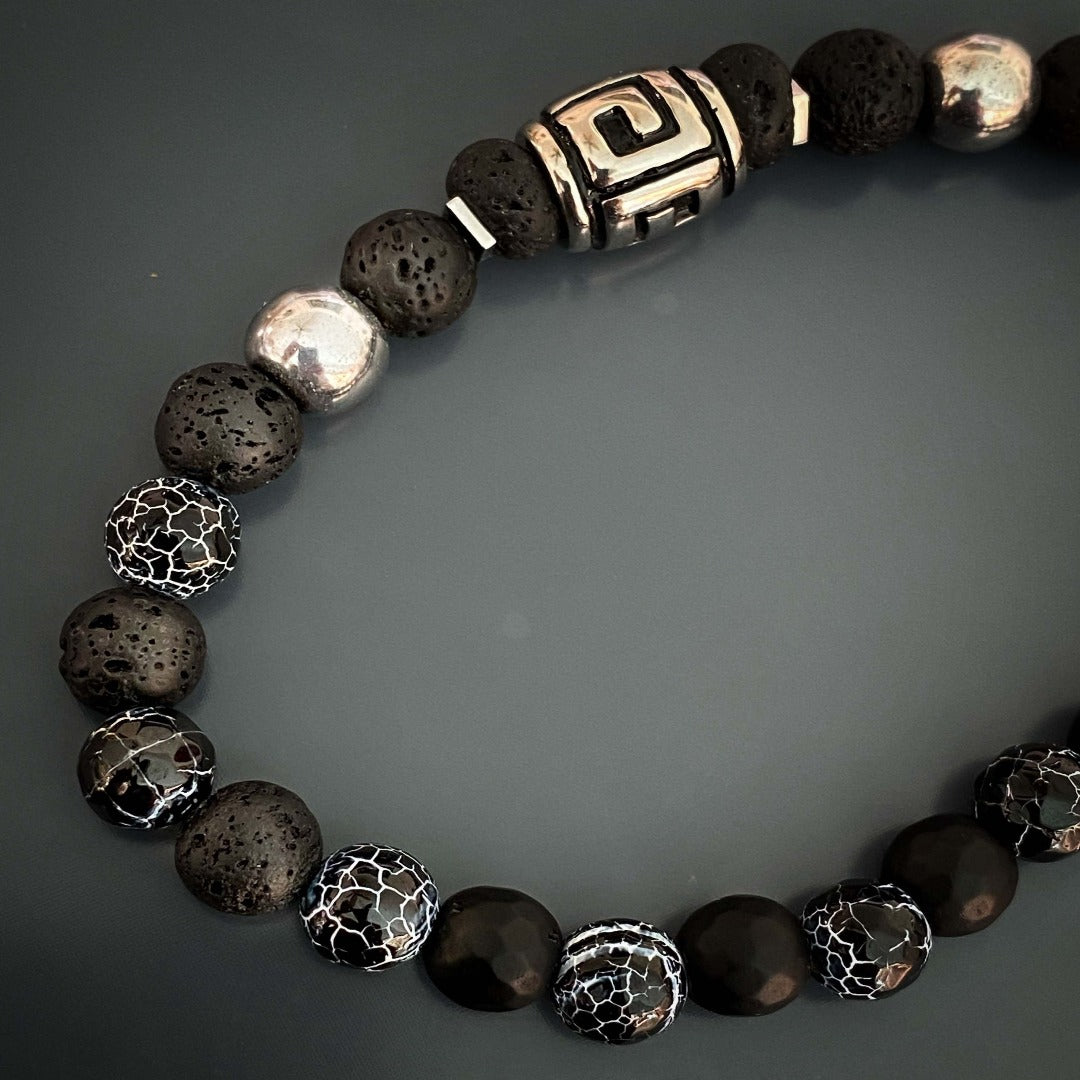 Embrace a sense of grounding and confidence with the Courage Lava Rock Men&#39;s Bracelet. Crafted with black lava rock and crackle agate stone beads, this handmade bracelet promotes inner strength and courage. The silver hematite beads add a touch of style to this powerful accessory.