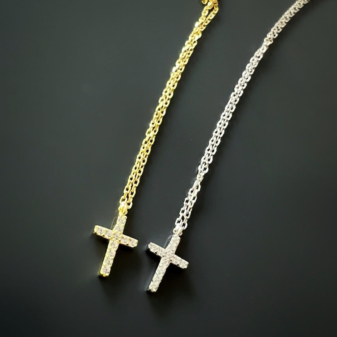 A close-up view of the Dainty Diamond Cross Necklace showcasing the intricate details of the sterling silver cross pendant and the sparkling CZ diamond.