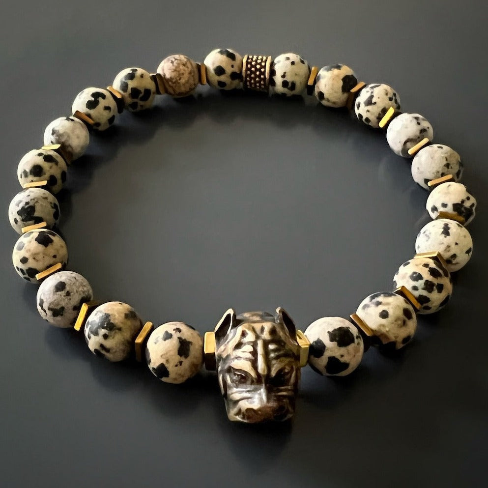 An image with a hand model demonstrating the adjustable feature of the Dalmatian Jasper Dog Bracelet, highlighting its ability to fit comfortably on various wrist sizes.