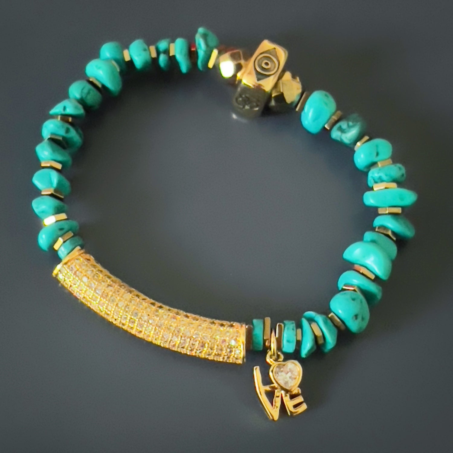 the Diamond and Turquoise Love Bracelet, showcasing its stunning combination of natural nugget turquoise stone beads, gold hematite spacers, and a gold plated charm with a simulated diamond. 