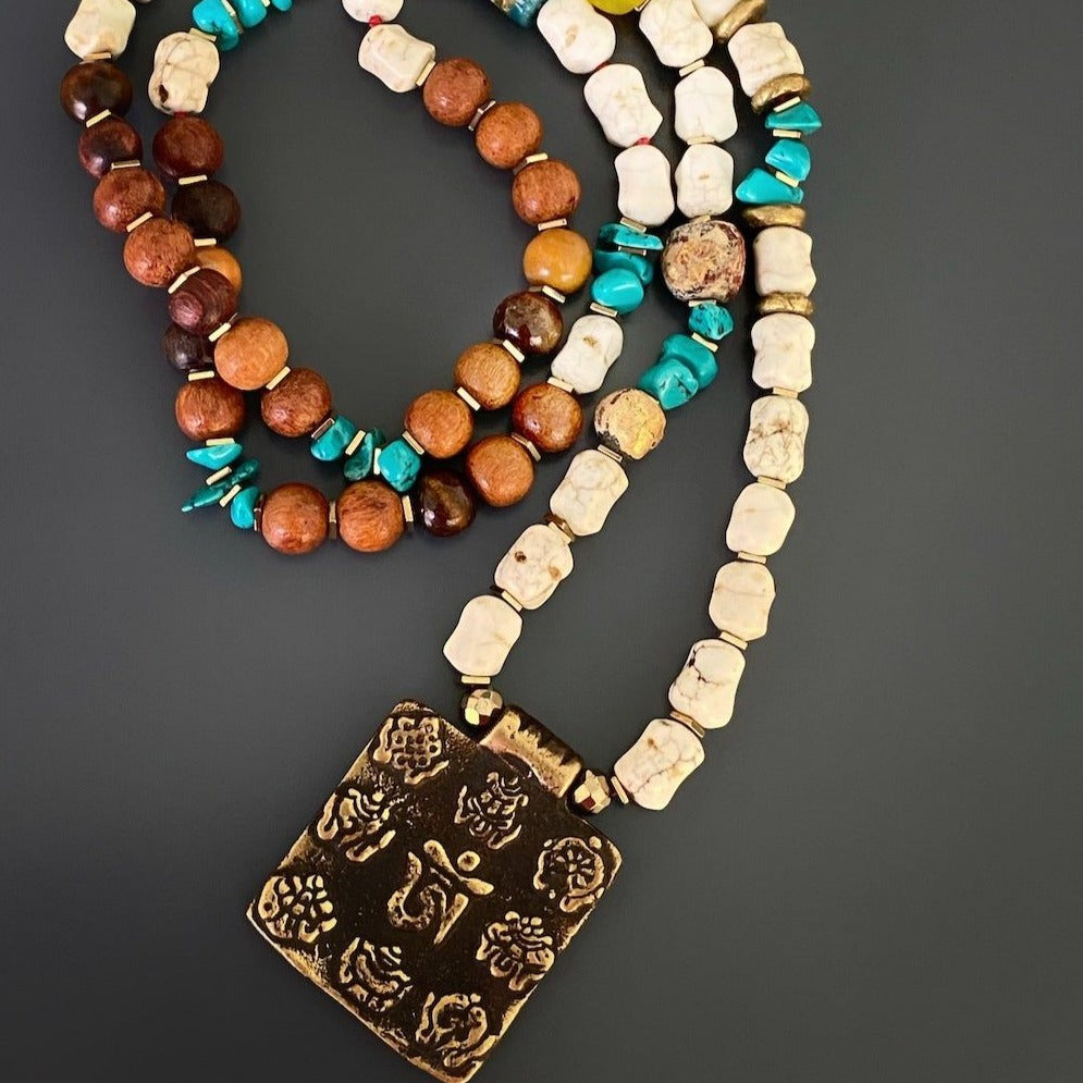 Handcrafted Nepal Necklace - A collection of handcrafted beads and a unique Om Mantra pendant come together to create this Ethnic Nepal Om Necklace. Each bead is carefully selected and strung, resulting in a truly one-of-a-kind piece of jewelry.