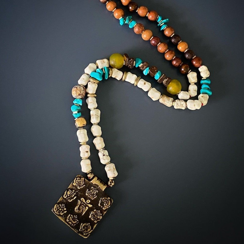 Vibrant Ethnic Necklace - A stunning display of the Ethnic Nepal Om Necklace, showcasing the vibrant colors of the African beads and turquoise stones. The necklace exudes a sense of cultural diversity and beauty.