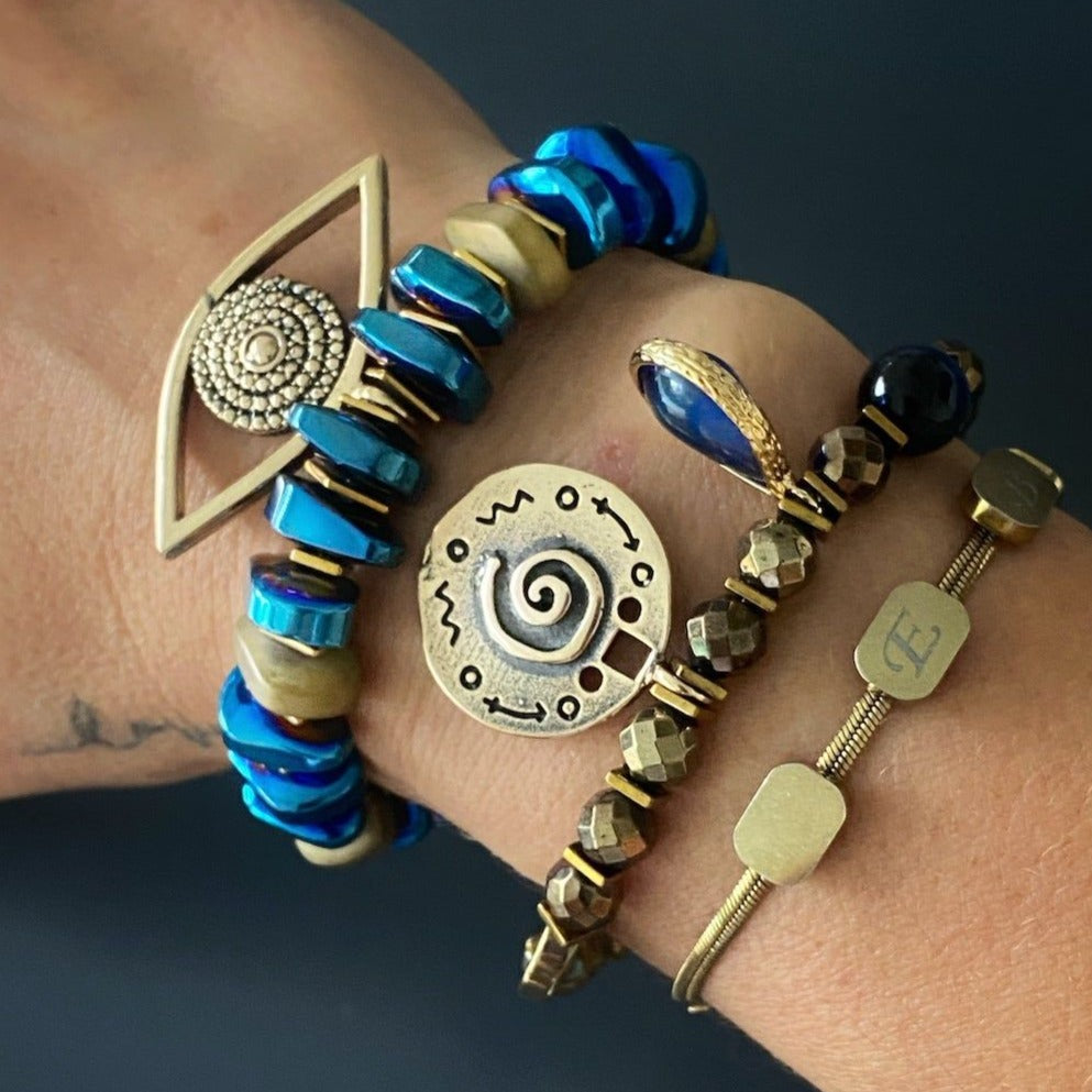 Hand model wearing the stunning Evil Eye Protector Bracelet, showcasing its elegant design and the combination of gold and blue hues.