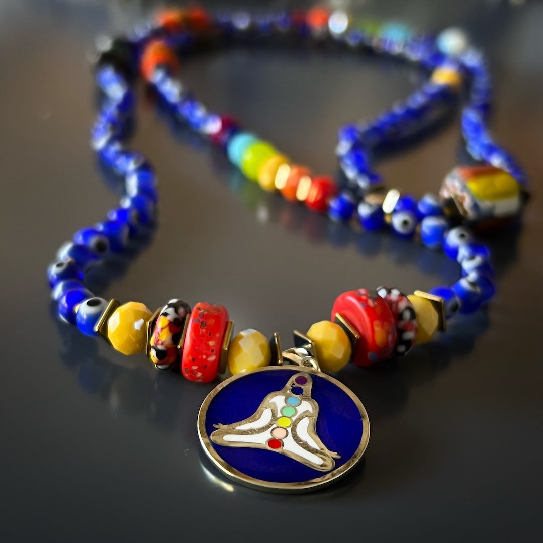 A close-up view of the Evil Eye Chakra Mala Necklace, highlighting the intricate detail of the evil eye beads and colorful faceted crystal beads. This spiritually meaningful necklace is handcrafted to bring intense spiritual energy, healing, and protection.