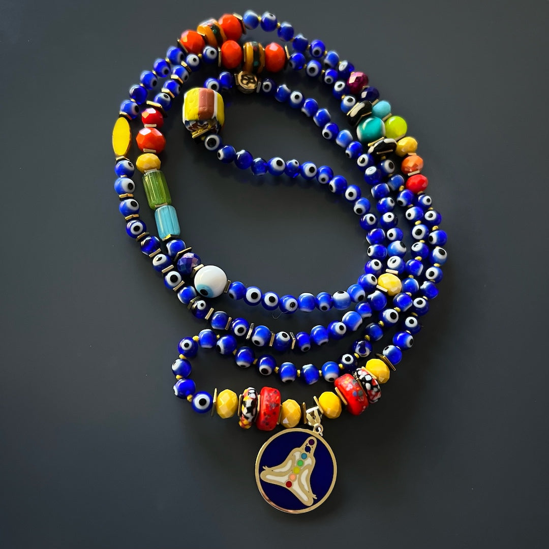 A depiction of the Nepal meditation beads and the hand-knotted jewelry rope in the Evil Eye Chakra Mala Necklace. These elements emphasize the necklace&#39;s connection to mindfulness and spiritual practices.