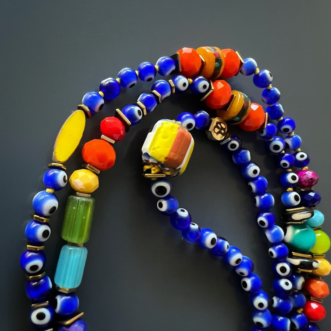 An image focusing on the vibrant and colorful African beads in the Evil Eye Chakra Mala Necklace. These beads add a touch of cultural significance and visual appeal to the handmade necklace.