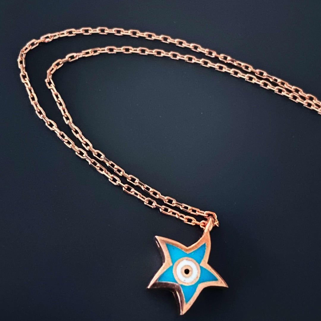 Delicate Evil Eye Gold Star Necklace featuring a star-shaped pendant with blue and white enamel on a gold plated chain.
