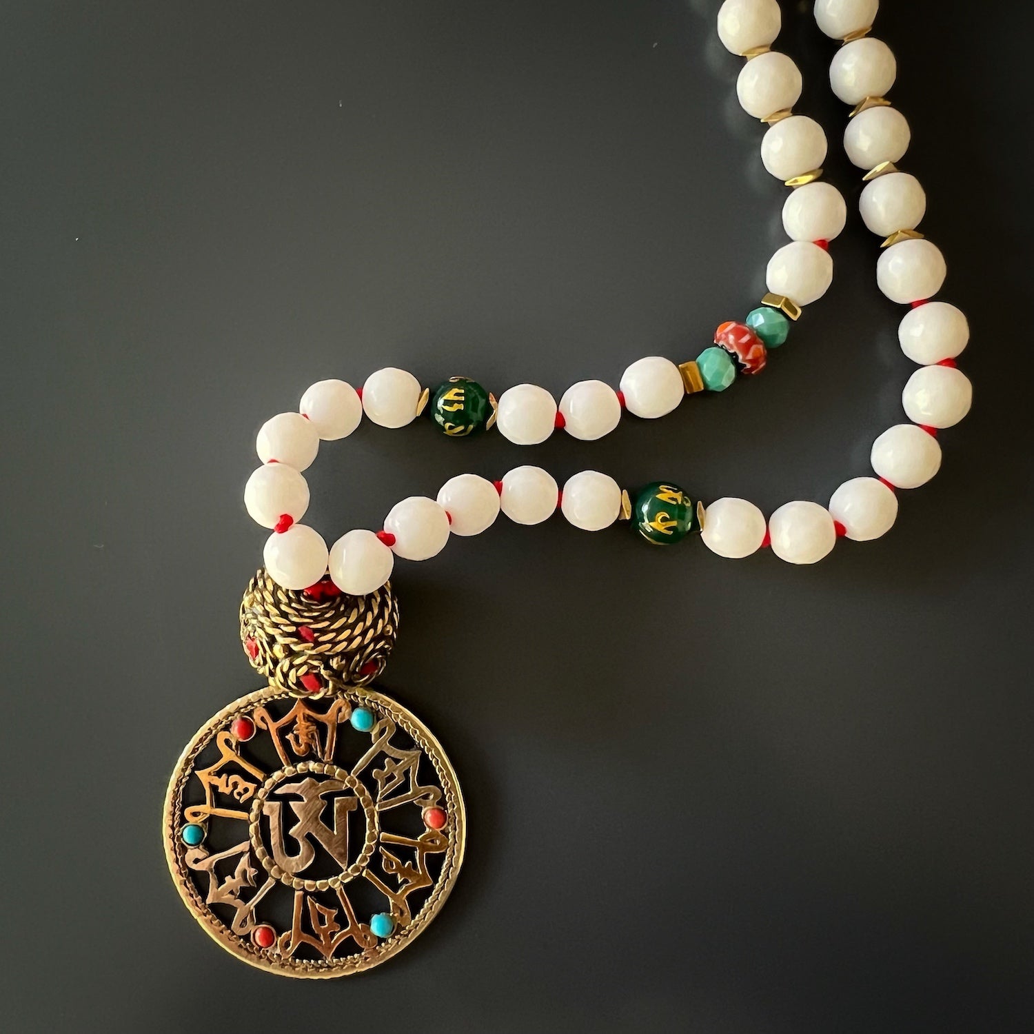 Handmade Eye Of The Buddha Necklace - Unique combination of white Jade stones, Nepal mantra beads, and a bronze Om charm for a meaningful accessory.