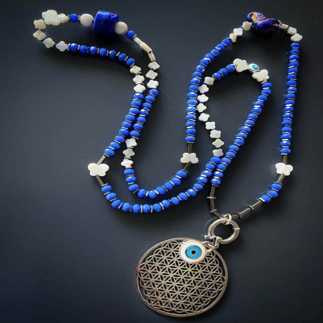 Unique Flower of Life Necklace - Handcrafted piece with 4mm faceted blue crystal beads, silver hematite spacers, and a Sacred Geometry-inspired Flower of Life pendant symbolizing creation and connection.