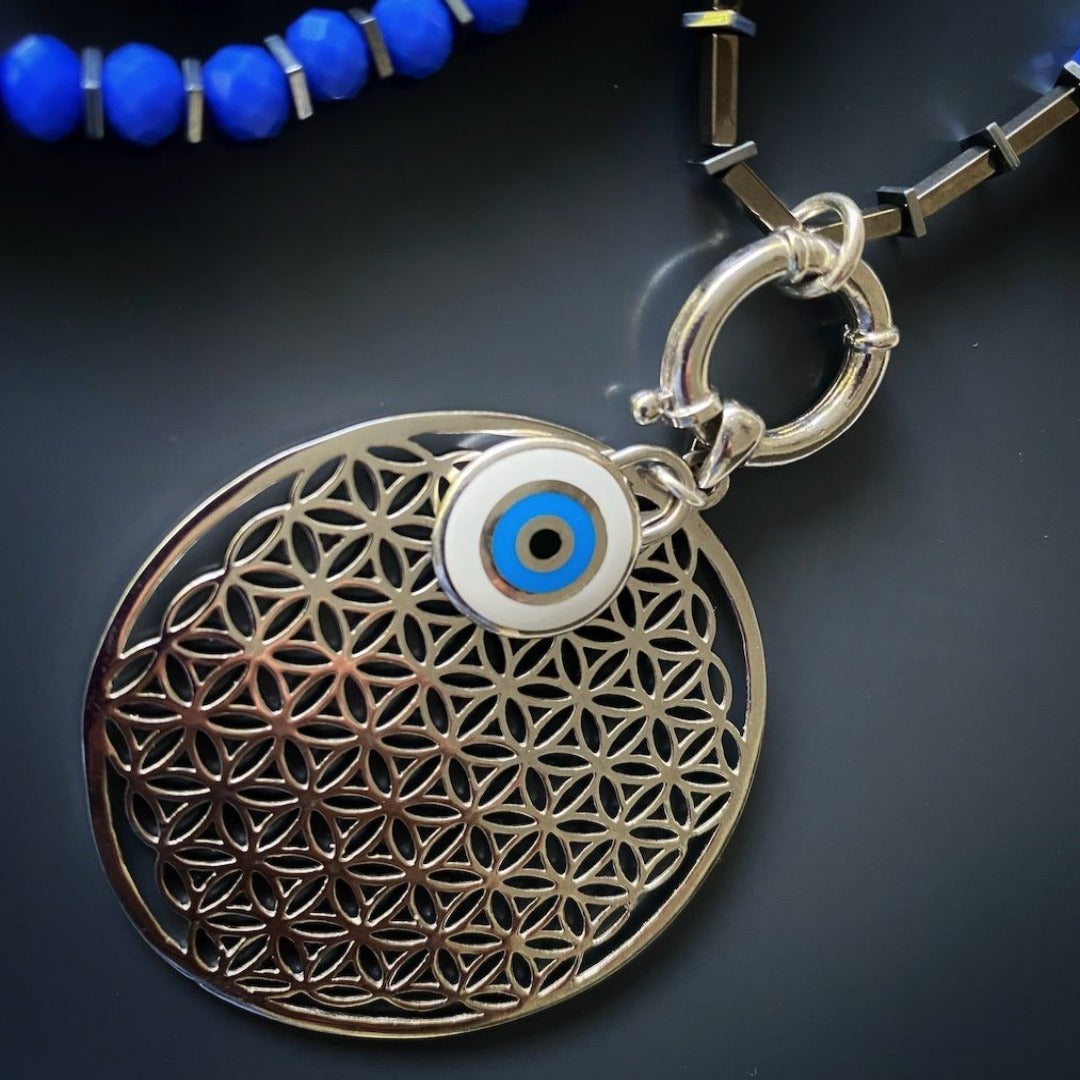 Meaningful Flower of Life Necklace - Exquisite accessory featuring a Sacred Geometry-inspired pendant, evil eye charm, and African elephant bead, handmade for protection, luck, and unity.