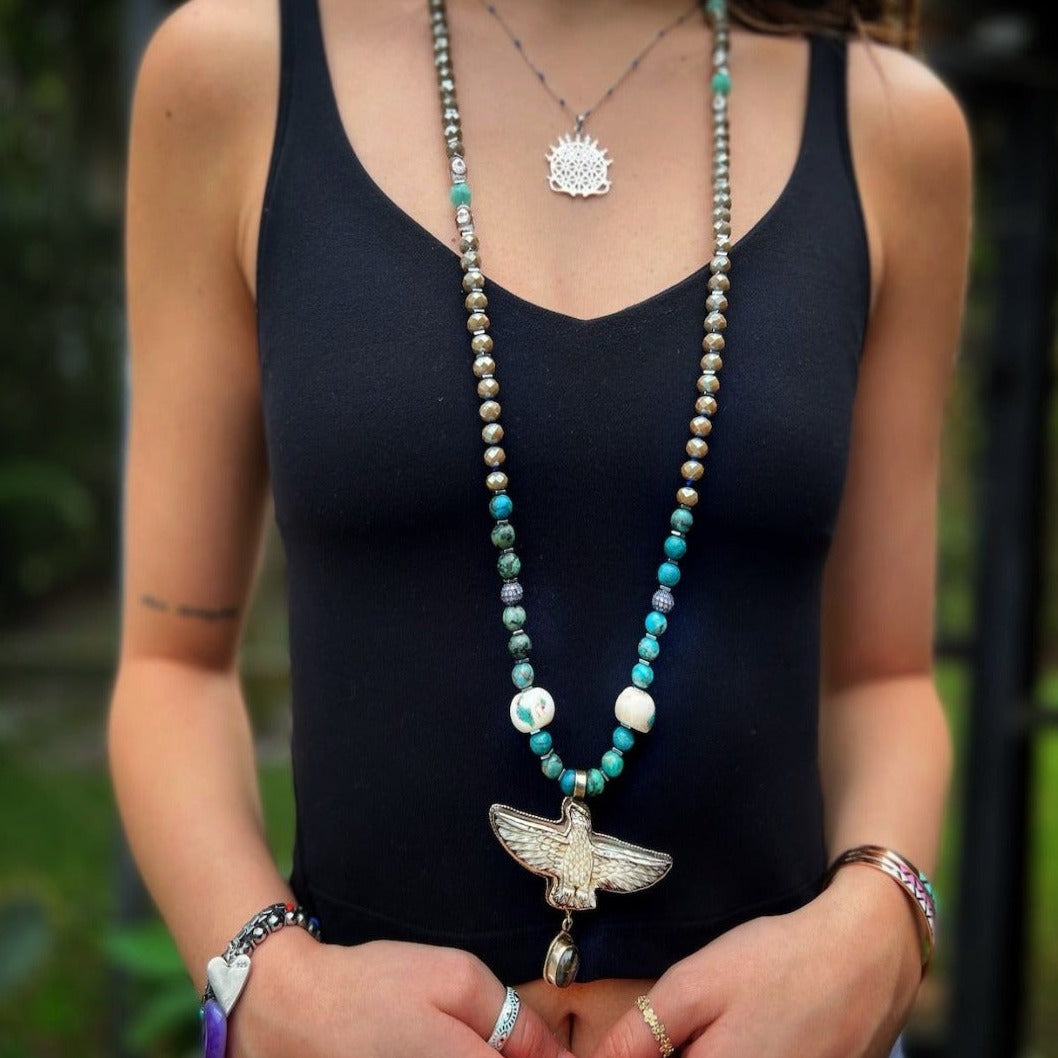 Bold Eagle Pendant Necklace - Model showcasing a unique accessory featuring turquoise, crystal beads, and a hand-carved eagle pendant, symbolizing vision and power.